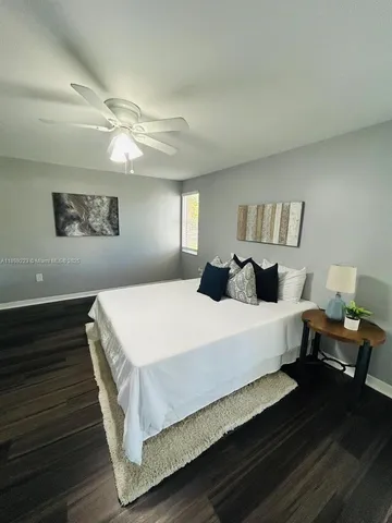 an empty room with wooden floor cabinet and windows