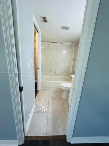 a view of a room with wooden floor and window