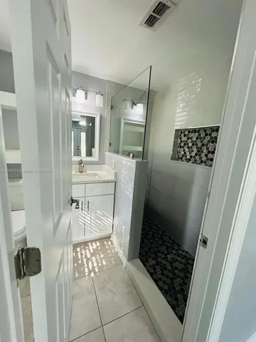 en empty room with wooden floor ceiling fan and window