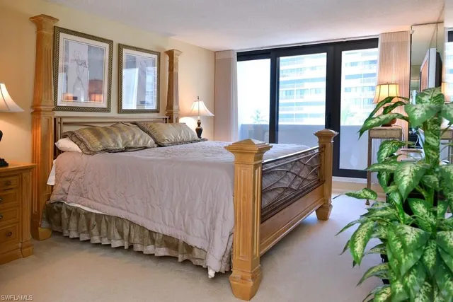 a bedroom with a bed and a potted plant