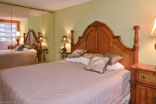 a bed sitting in a spacious bedroom next to a window