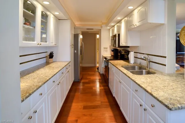 a kitchen with stainless steel appliances granite countertop a refrigerator and a sink