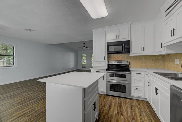 a kitchen with granite countertop a stove and a sink