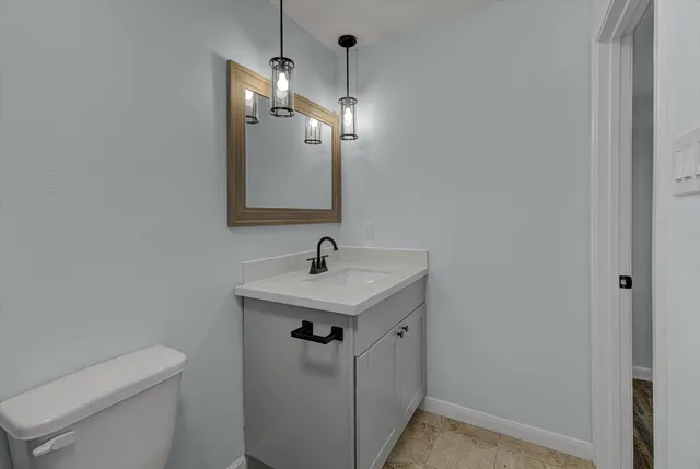 a bathroom with a sink a toilet and mirror