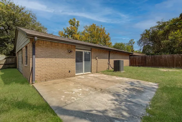 a front view of house with yard and trees in the background