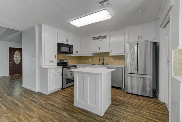 a kitchen with white cabinets and stainless steel appliances