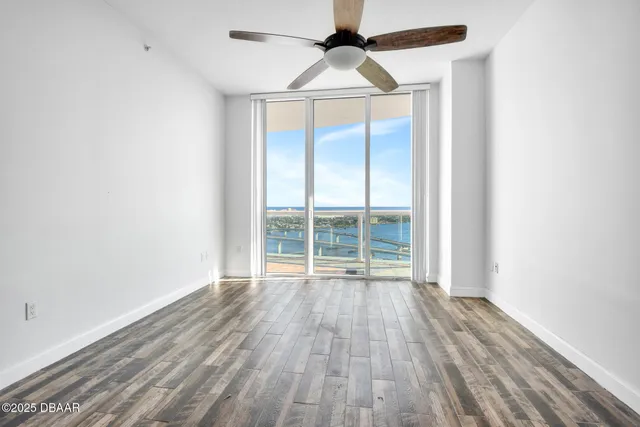 a bedroom with a large bed and a chandelier fan