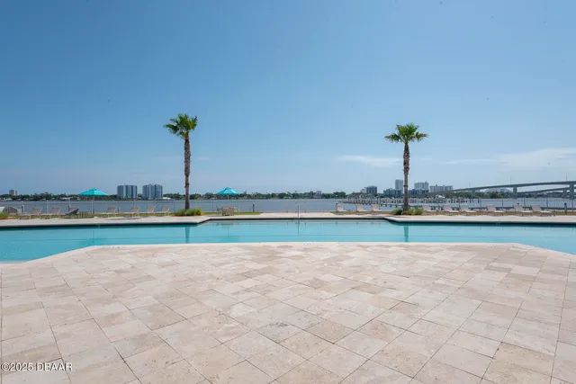 a view of swimming pool with outdoor seating and house in the background