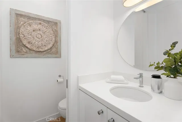 a bathroom with a sink mirror vanity and toilet