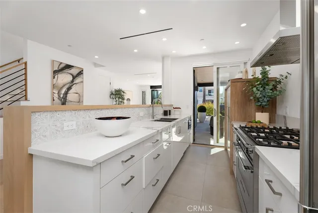 a kitchen with stainless steel appliances kitchen island a stove a refrigerator and a sink