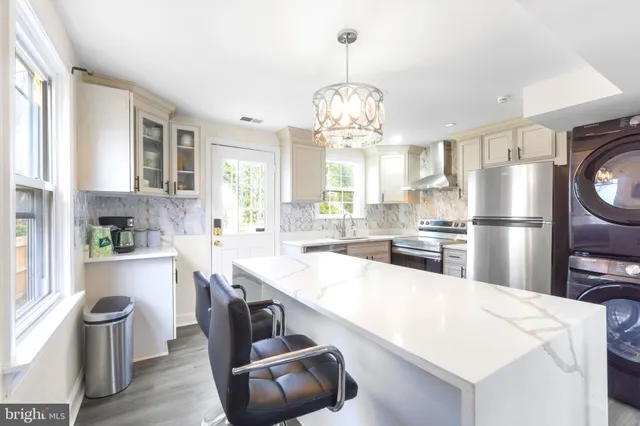 a kitchen with stainless steel appliances a table and chairs in it