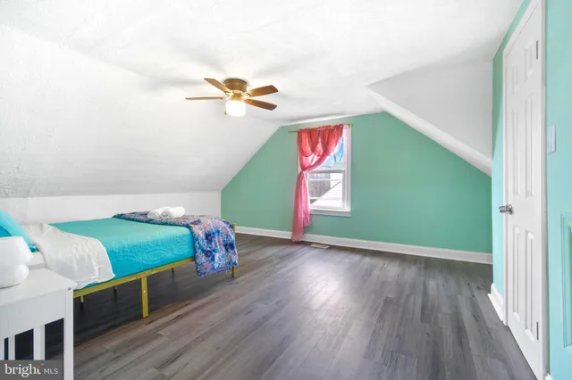 a bedroom with a bed and a wooden floor