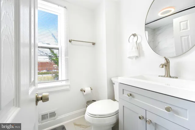 a bathroom with a sink a toilet and a mirror