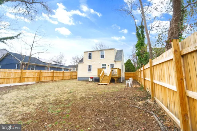 a view of a house with a big yard and large tree