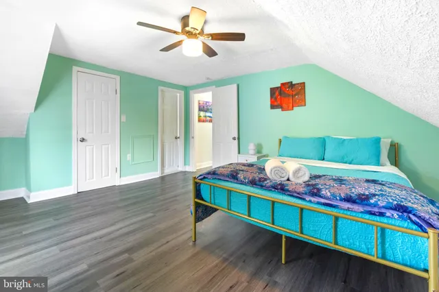 a bedroom with a bed and a wooden floor