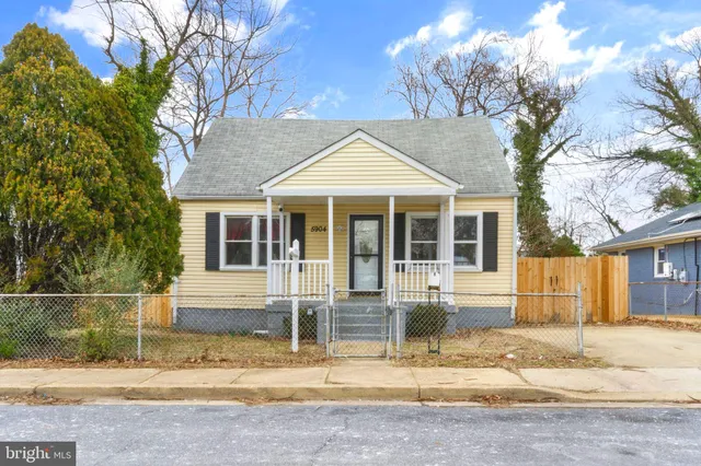 a front view of a house with a tree in front