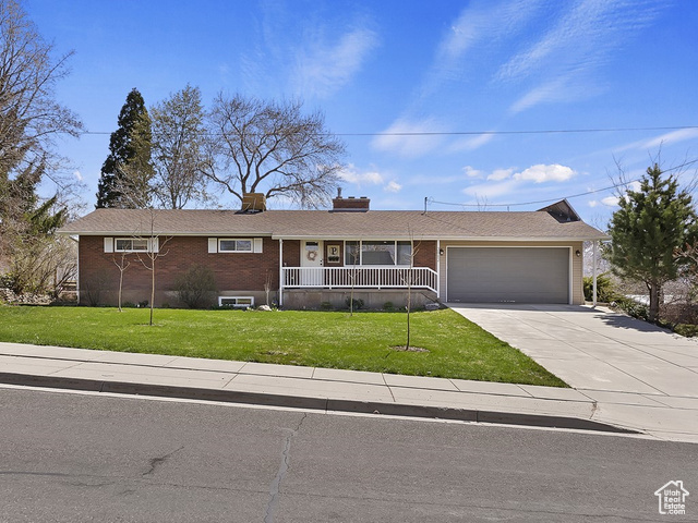 3862 North 900 West Pleasant View, UT 84414 - Photo 1 of 1 Ranch-style house featuring a front lawn, brick siding, a chimney, a garage, and driveway