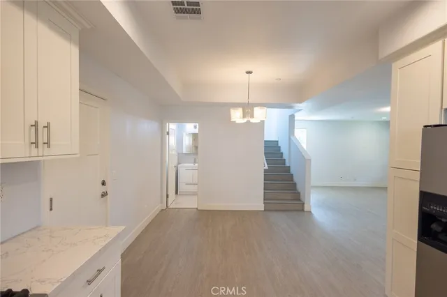 an empty room with wooden floor and entryway