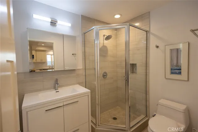a bathroom with a shower sink mirror and toilet