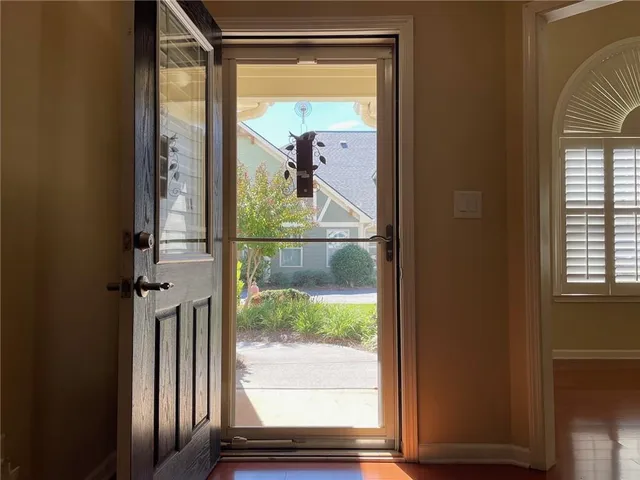 a view of an empty room with wooden floor and a fire place