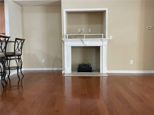 an empty room with wooden floor and natural light