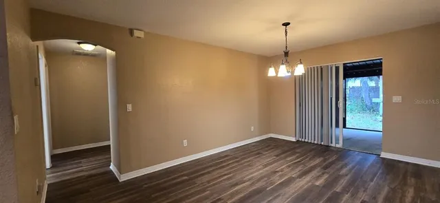 a view of a room with wooden floor and ceiling fan