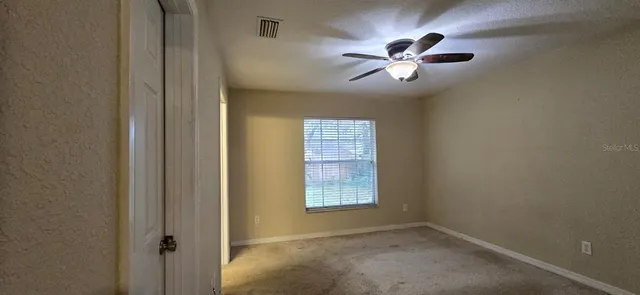 a view of a livingroom with a ceiling fan and window