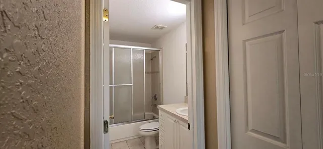 a bathroom with a granite countertop toilet a sink and shower
