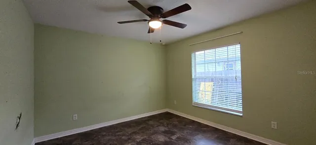 an empty room with a window and a fan