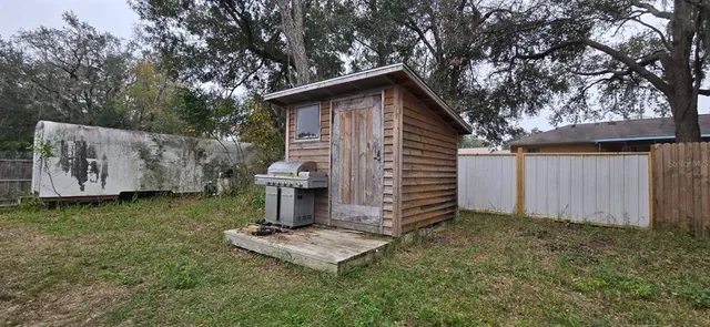 a view of a small house with yard and entertaining space