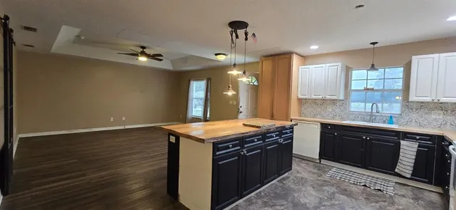 a kitchen with stainless steel appliances granite countertop a sink a stove and a wooden floors