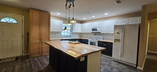 a kitchen with a refrigerator a sink and wooden cabinets