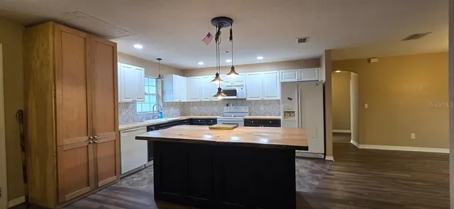 a kitchen with refrigerator cabinets and wooden floor