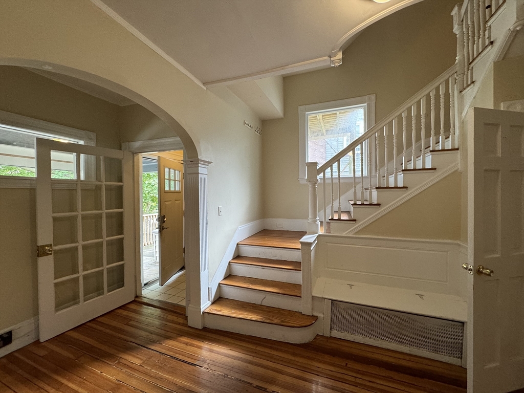 a view of entryway with wooden floor and front door