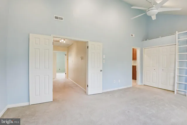 an empty room with fan and entrance