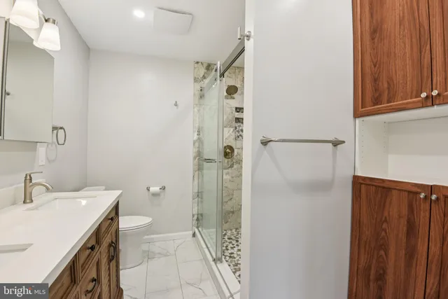 a bathroom with a sink a toilet and shower