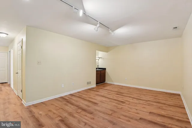 a view of empty room with wooden floor