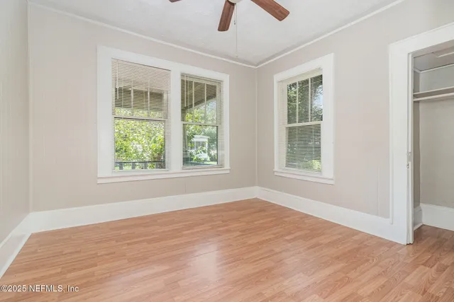 an empty room with windows and closet