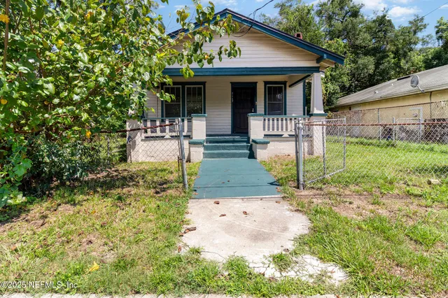 a view of house in front of a yard with potted plants