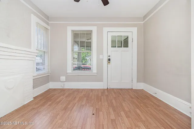 an empty room with wooden floor and windows