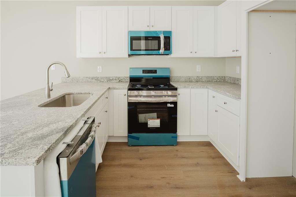 112 Neal Avenue Stockbridge, GA 30281 - Photo 5 of 19 a kitchen with granite countertop a sink stove and cabinets