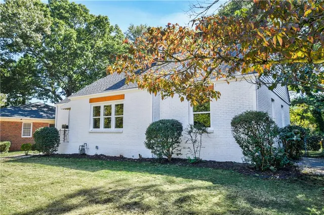 a backyard of a house with potted plants and large tree