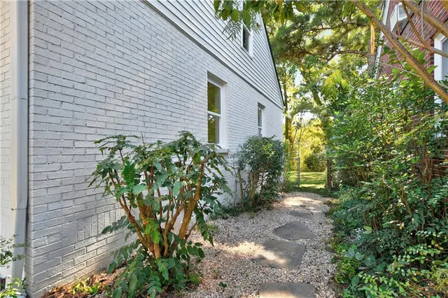 a view of a backyard with large trees and wooden fence