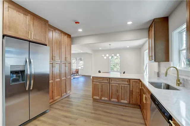 a kitchen with stainless steel appliances granite countertop a refrigerator a sink and a stove