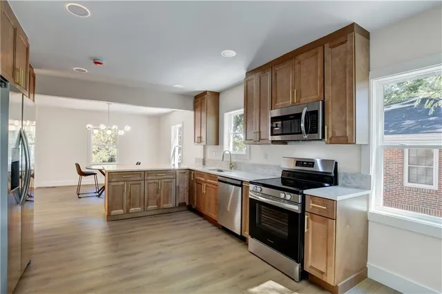 a kitchen with stainless steel appliances a stove sink microwave and cabinets