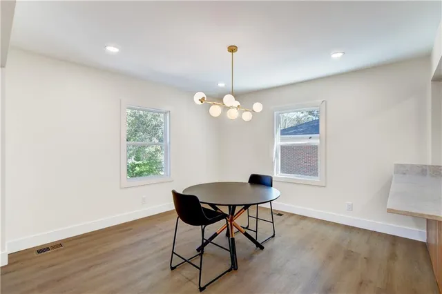 a dining room with wooden floor and a chandelier