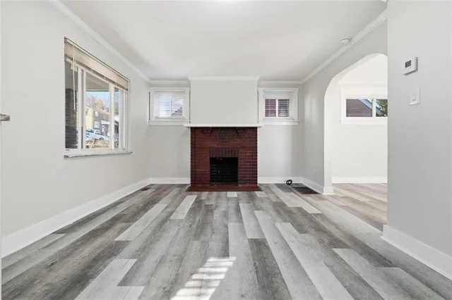 a view of empty room with wooden floor and fireplace