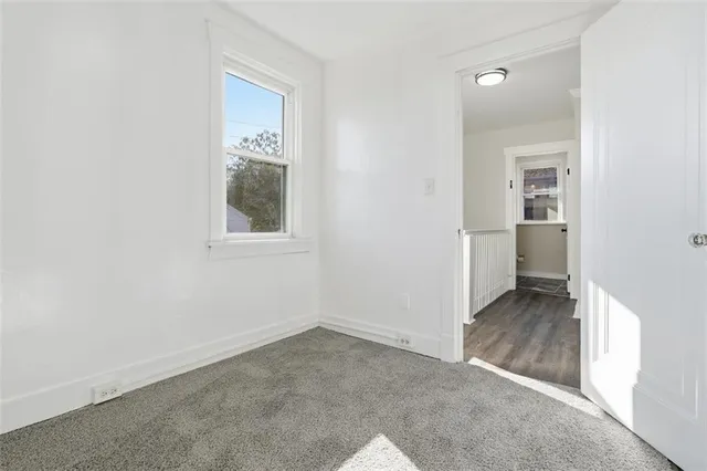 an empty room that has a grey walls and closet