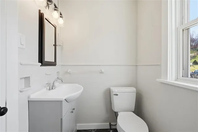 a bathroom with a toilet sink and mirror