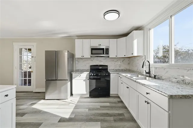 a kitchen with stainless steel appliances granite countertop a stove a sink and a refrigerator